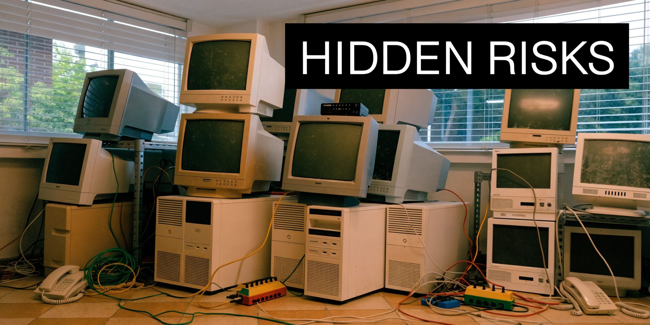 A room stacked with old CRT computer monitors and desktop towers representing electronic waste and office equipment.