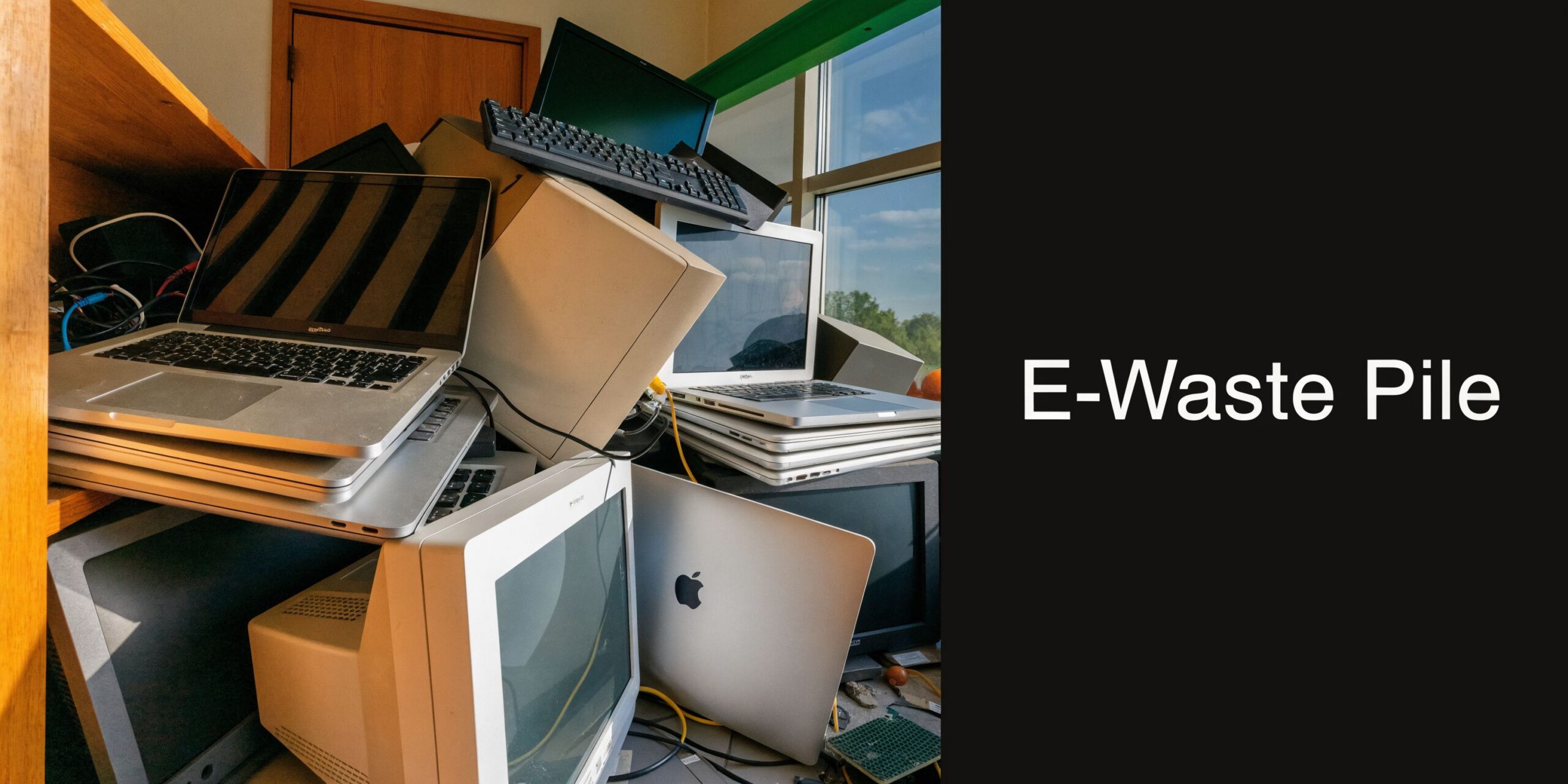A large chaotic heap of obsolete computers, laptops, and electronic waste items stacked near a window.